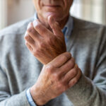 man holding wrist with opposite hand