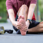 jogger holding foot in pain