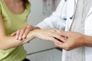 doctor examining woman's wrist for carpal tunnel syndrome